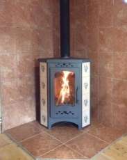 Недорогая печь-камин Бавария угловая с плитой незабудка Амазонка бай фото в интерьере в Слониме
