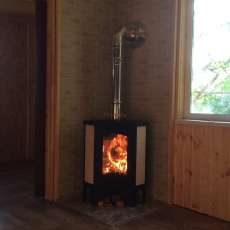 Стальной камин с большим стеклом Бавария угловая Амазонка бай фото в интерьере в Слониме